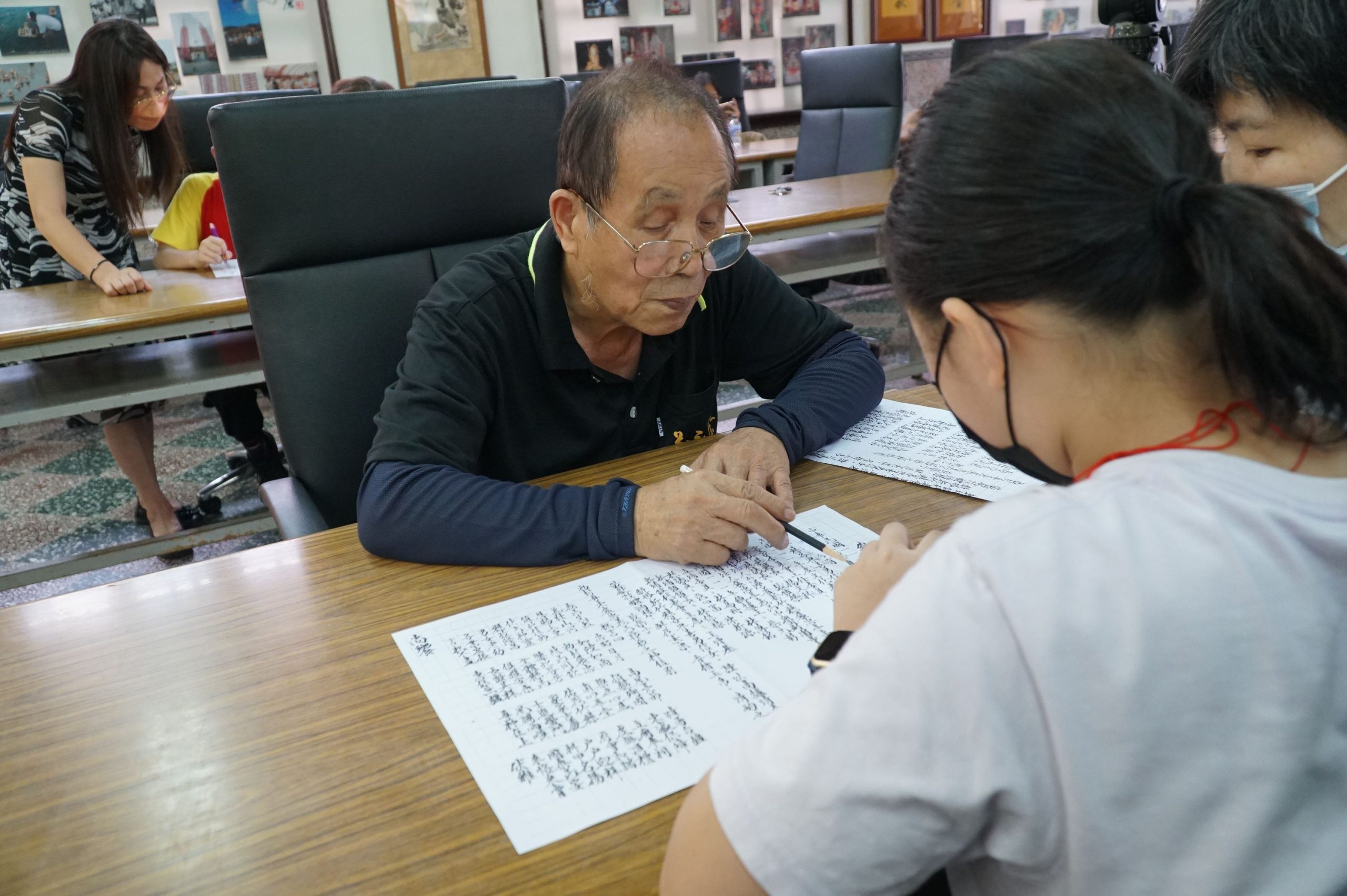 義民廟的廟公林邦雄（左）細心指點學生，以標準海陸腔客語唸祝禱文。新竹縣政府提供
