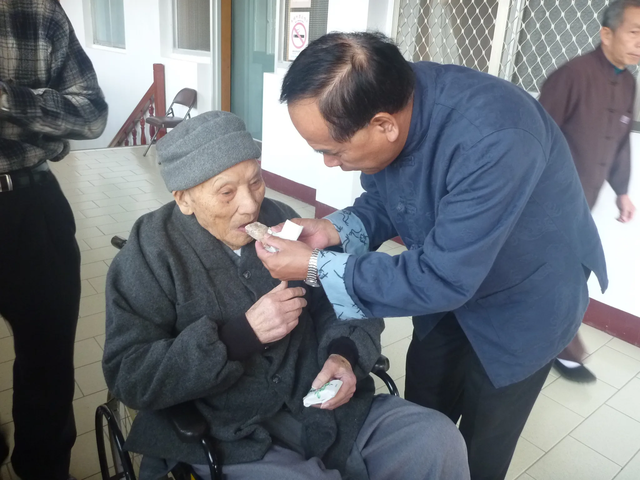 真修師父(俗名范壬坤)在勸化堂修行半世紀,年逾百歲時,兒子黃錦源服侍在側,親餵軟糖。獅頭山勸化堂提供