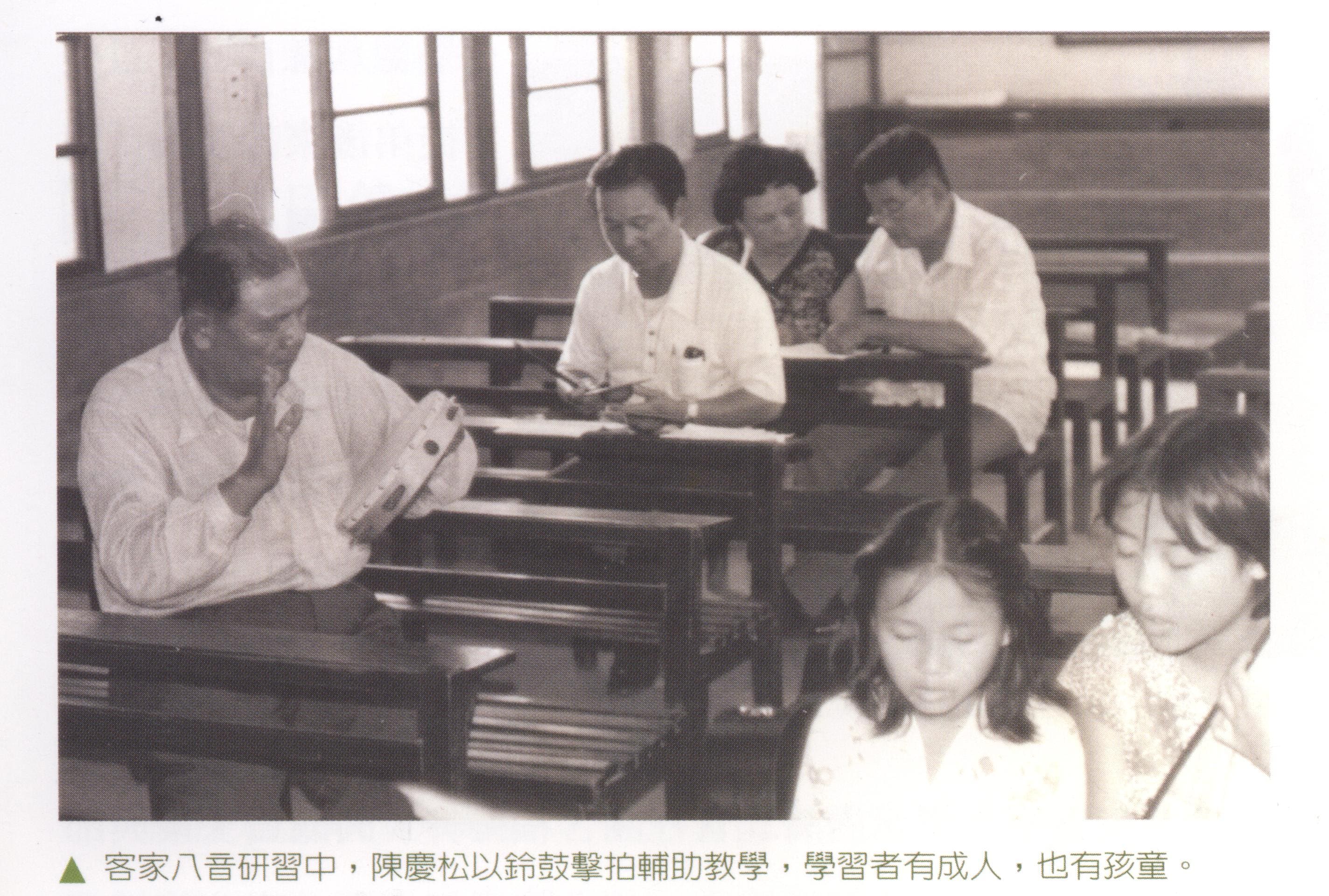 陳慶松指導客家八音，學員有成人，亦有孩童，他用鈴鼓擊拍輔助教學。鄭榮興提供