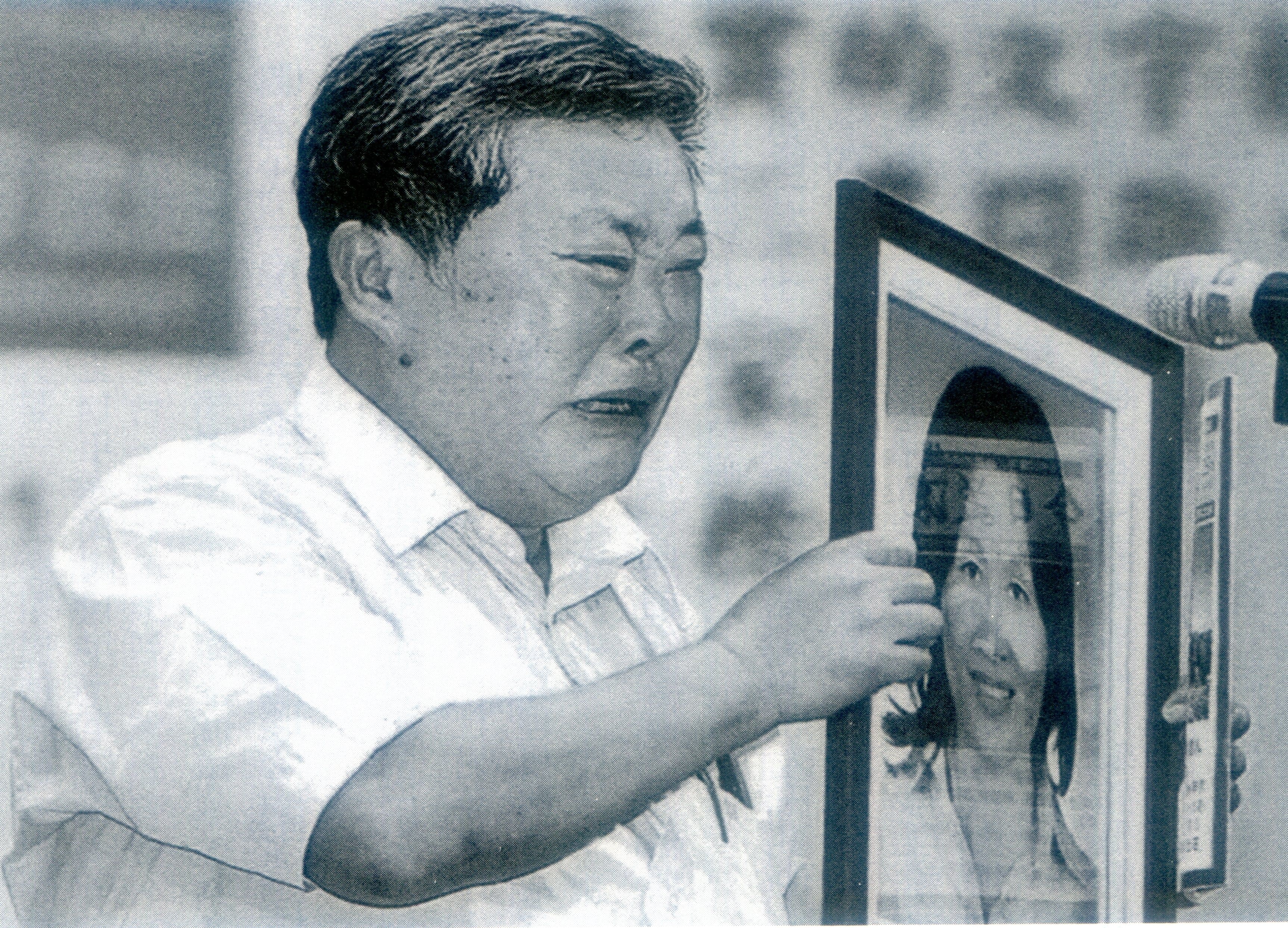 2013年黃森松帶著太太林錦霜遺照回母校政大，接受傑出校友表揚，他因思妻涙流滿面。此照放於《台灣客家簡明史》內頁末頁。黃森松提供