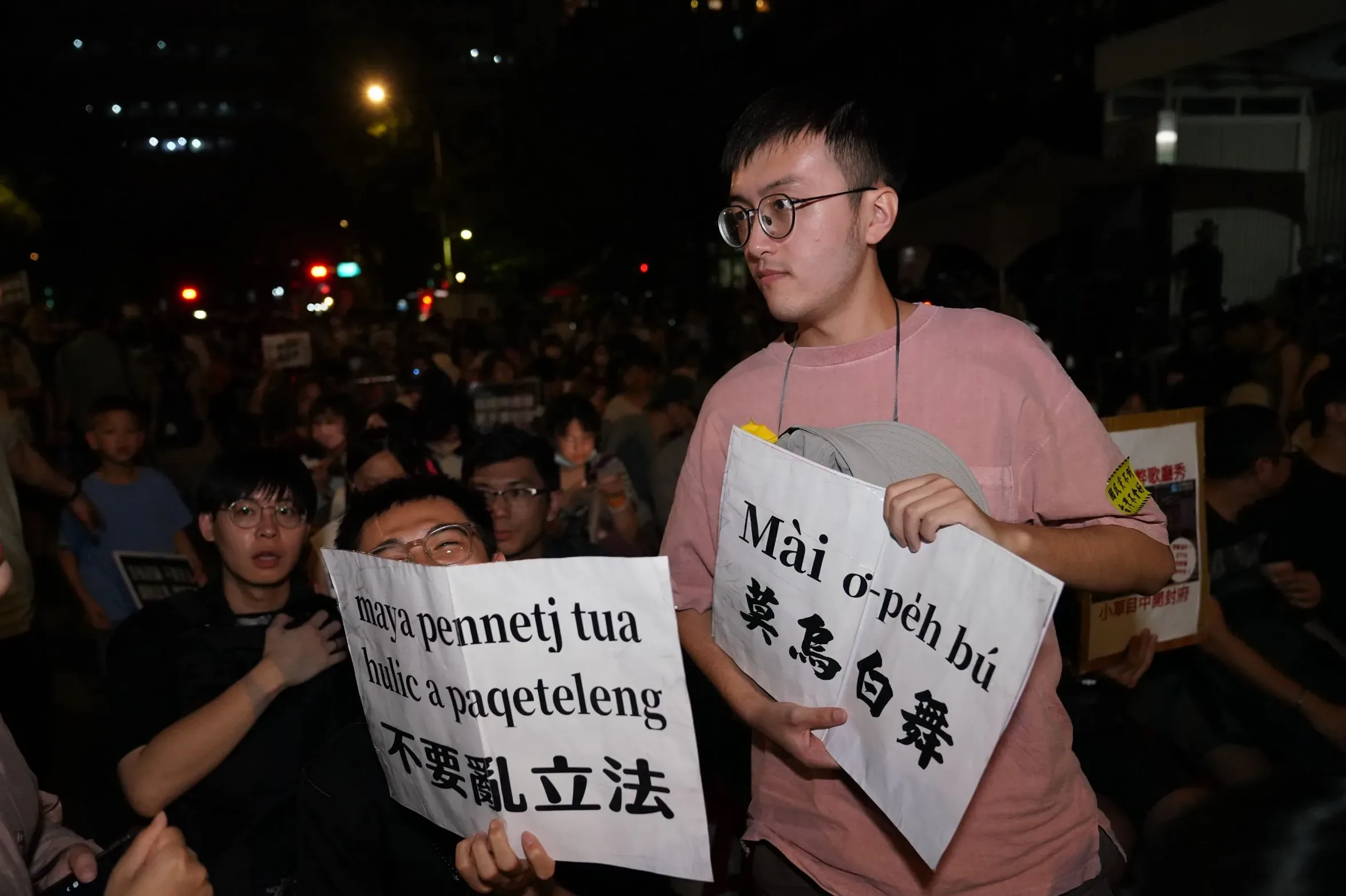 簡姓民眾與友人舉著河洛語、排灣族語的口號抗議立法院職權法案修法。李台源攝