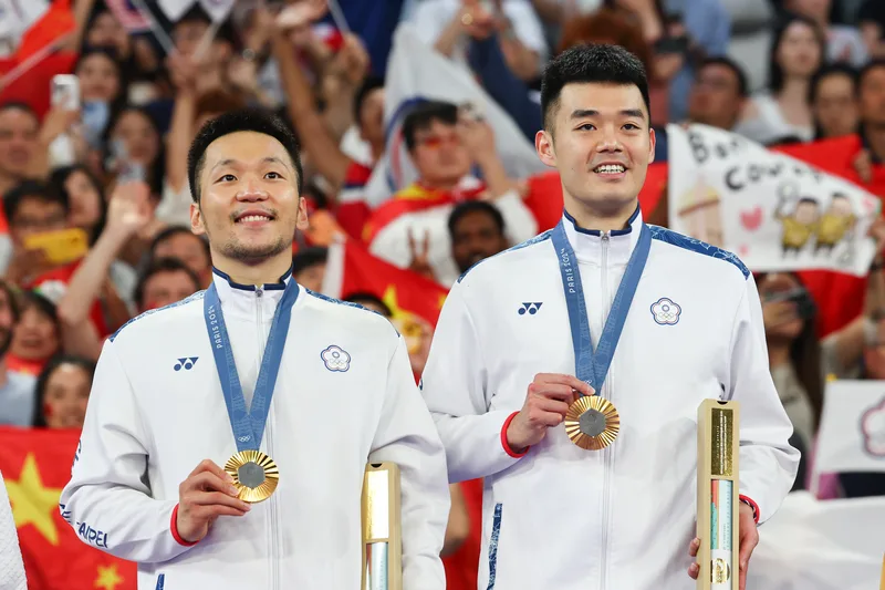 「麟洋配」李洋、王齊麟成功摘金，各大商家祭出優惠慶祝。中央社