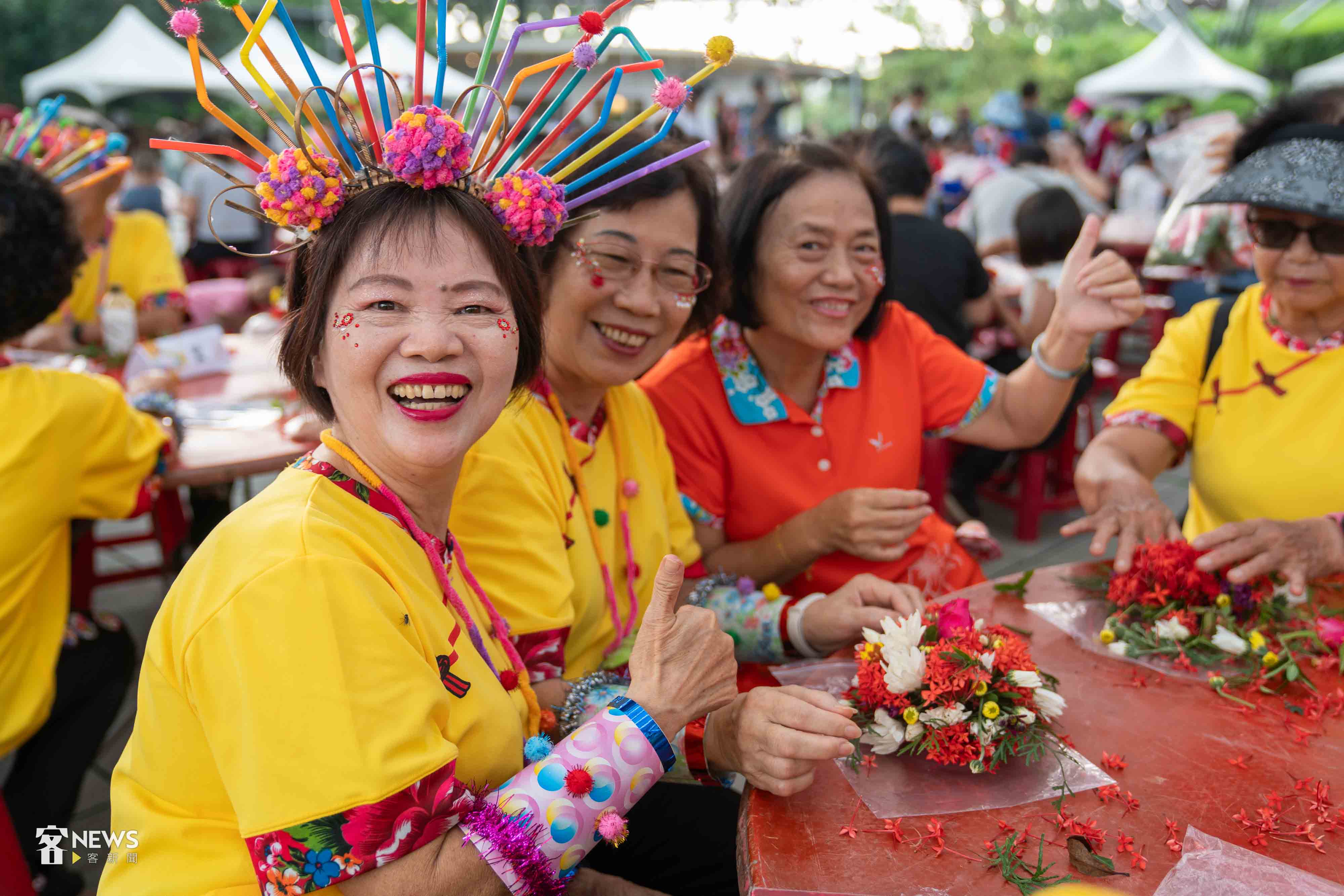 盛裝打扮的民眾開心製作疊盤花。李台源攝。資料照片