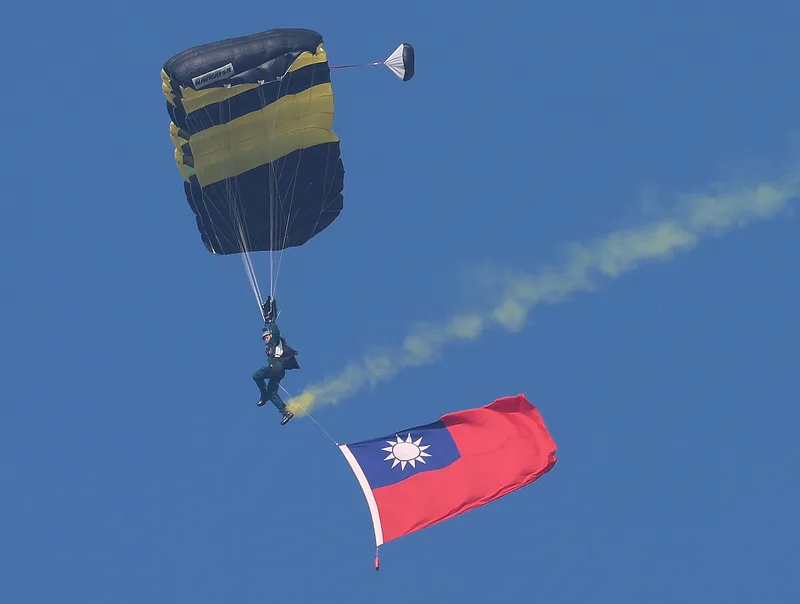 神龍小組實施高難度的3人扇形、Y形疊傘,同時在空中展開中華民國國旗(圖),展現精湛操傘技術。中央社