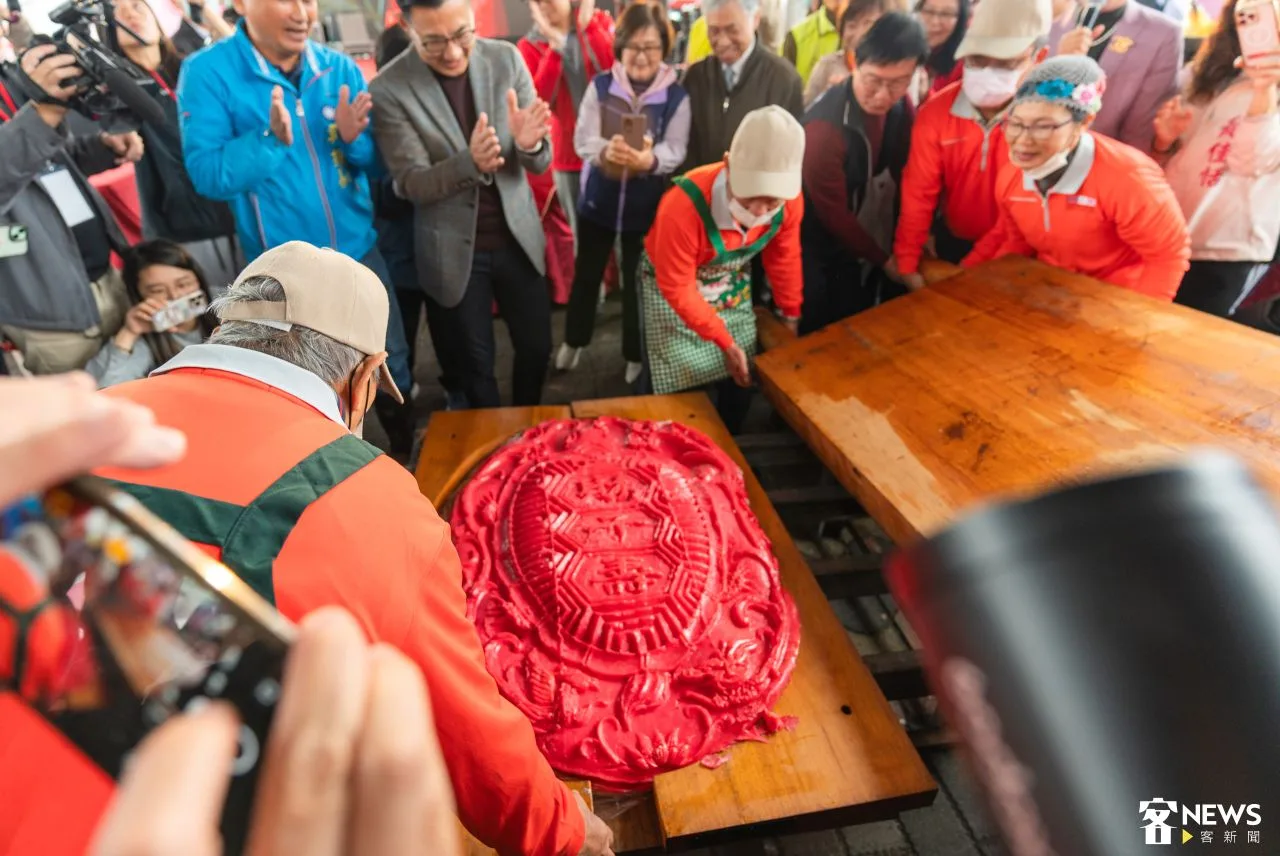每年東勢新丁粄節都吸引許多民眾參與。圖為去年東勢新丁粄節時,師傅們掀開粄模,120斤新丁粄正式亮相。資料照片.朱愷元攝