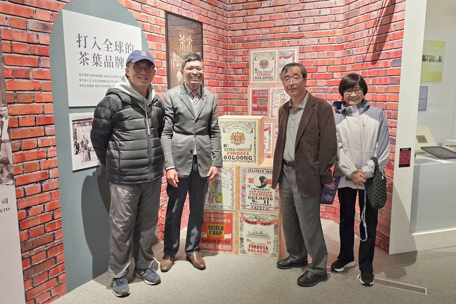 日本菊池秀明教授(右2)、臺大羅士傑副教授(左1)與何金樑主任(左2)一同在「拼.靚」特展中「茶產業」與「茶金」場景前留下合影。客發中心提供