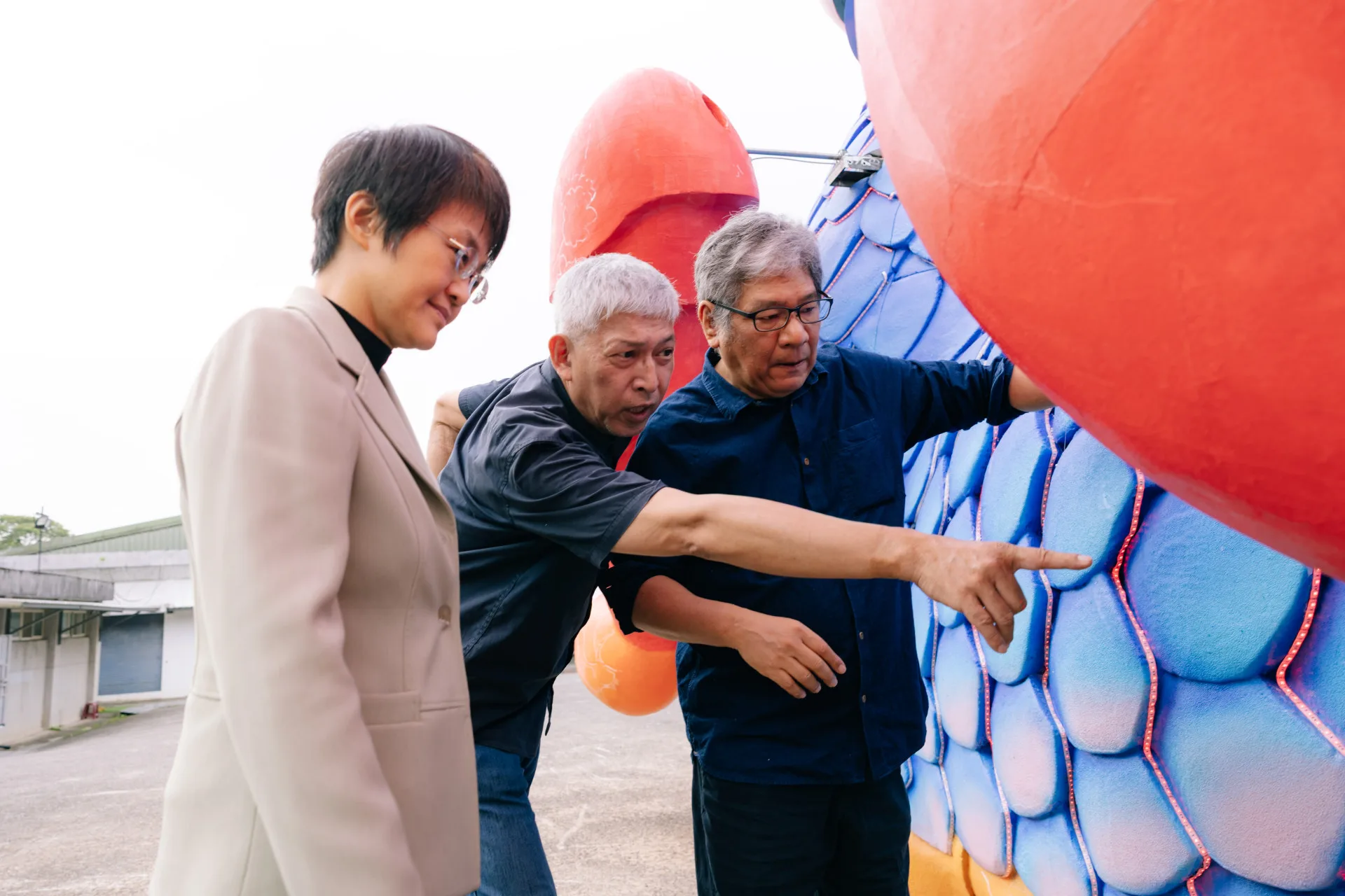 古秀妃(左)在紙風車劇團創辦人李永豐(右)、團長任建誠(中)帶領參觀《燈怪》裝置。客委會提供