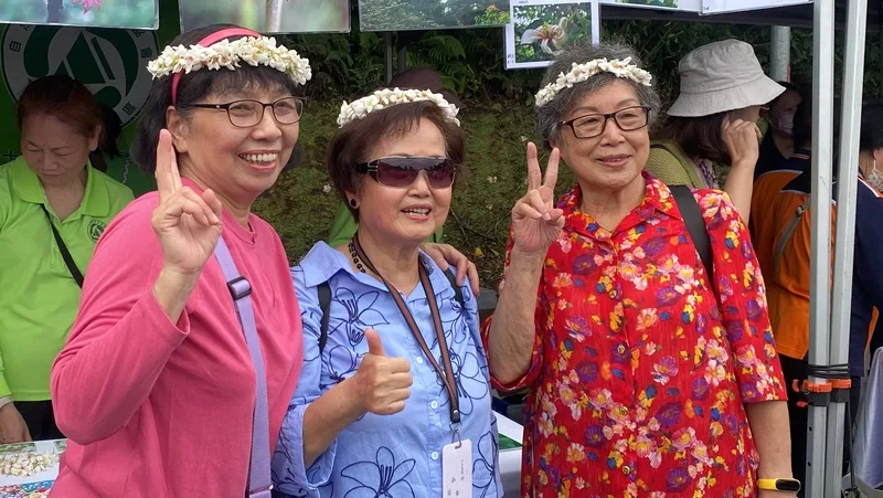 2025新北市客家桐花祭「青春桐樂會」19日在土城區熱鬧登場,吸引許多民眾上山參與,開心戴著桐花花環合影。中央社