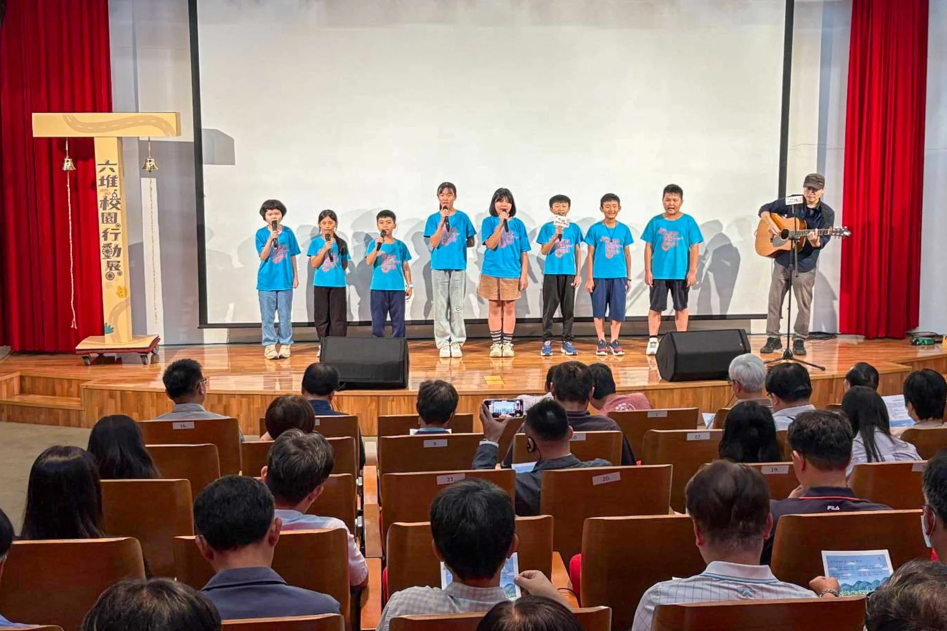客家音樂才子黃瑋傑與美濃龍肚國小學生共同演唱主題曲〈跈等〉。客發中心提供