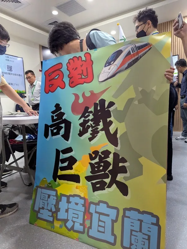 環境部5日上午9時30分舉辦「高鐵延伸宜蘭計畫環境影響評估報告書初稿」專案小組初審會議。反對方舉「高鐵巨獸」看板，辦理登記進場。中央社