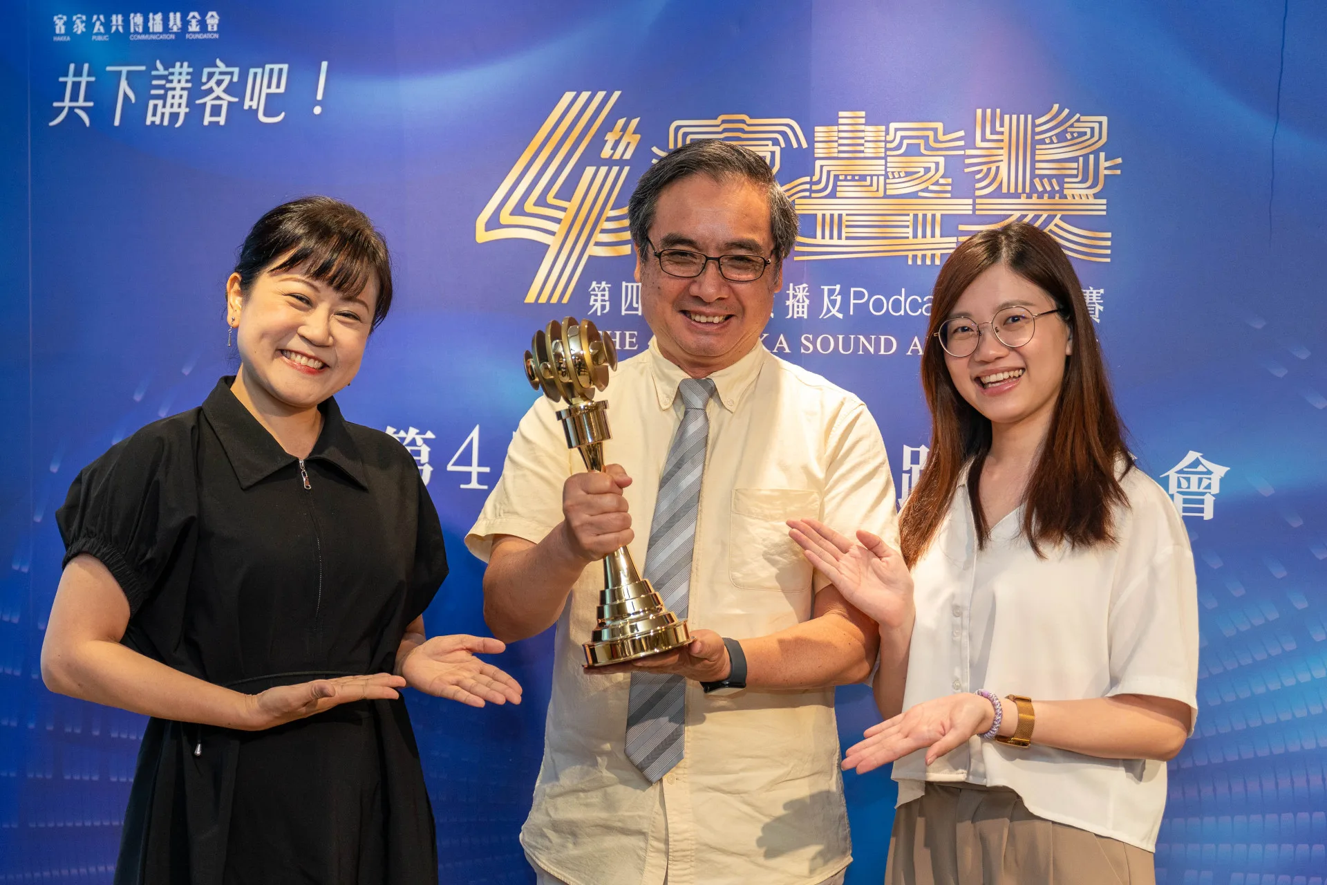 客傳會董事長陳邦畛(中)與去年得獎人宋菁玲(左)、羅彥妤(右)一起展示全新設計的客聲獎獎盃。李台源攝