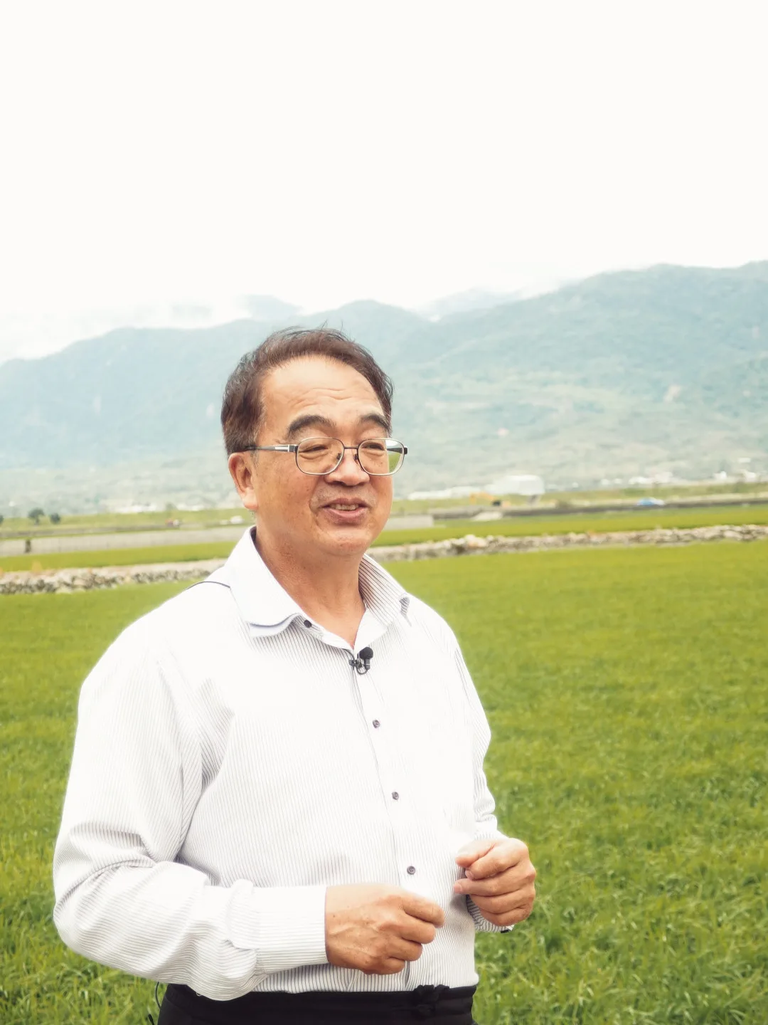戴文達,領著大家到他小時候做田的河壩地,他回憶說 :「這地上都是大大小小的石頭,要用手一個一個搬開,當年開田很辛苦啊!」李翊彤攝