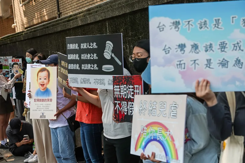 台北地方法院國民法庭13日下午2時30分宣判。排隊聽判民眾在地院外舉牌表達立場。中央社