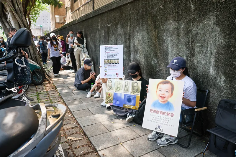 台北地方法院國民法庭13日下午2時30分宣判。排隊聽判民眾在地院外舉牌表達立場。中央社