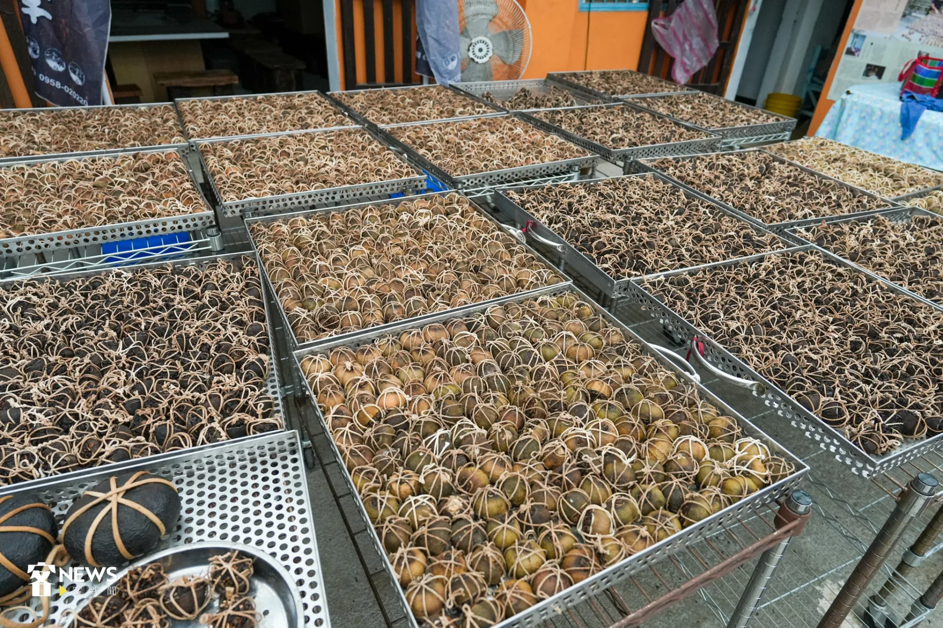 幾顆黑亮的酸柑茶、上千顆檸檬製成的「半顆茶」鋪開在白鐵盤上。蔡依璇攝