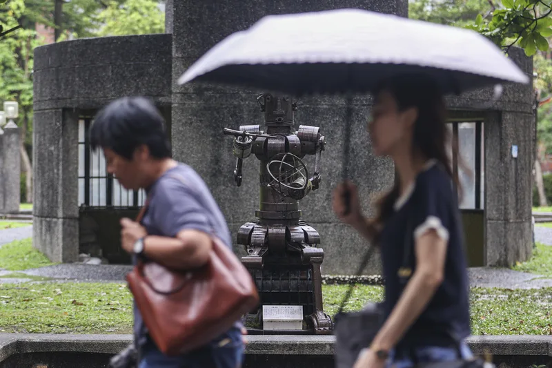 26日北台灣雲量多,仍有局部短暫雨,29日下一波鋒面南下,各地慎防劇烈天氣。圖為台北市大安區民眾撐傘擋雨。中央社
