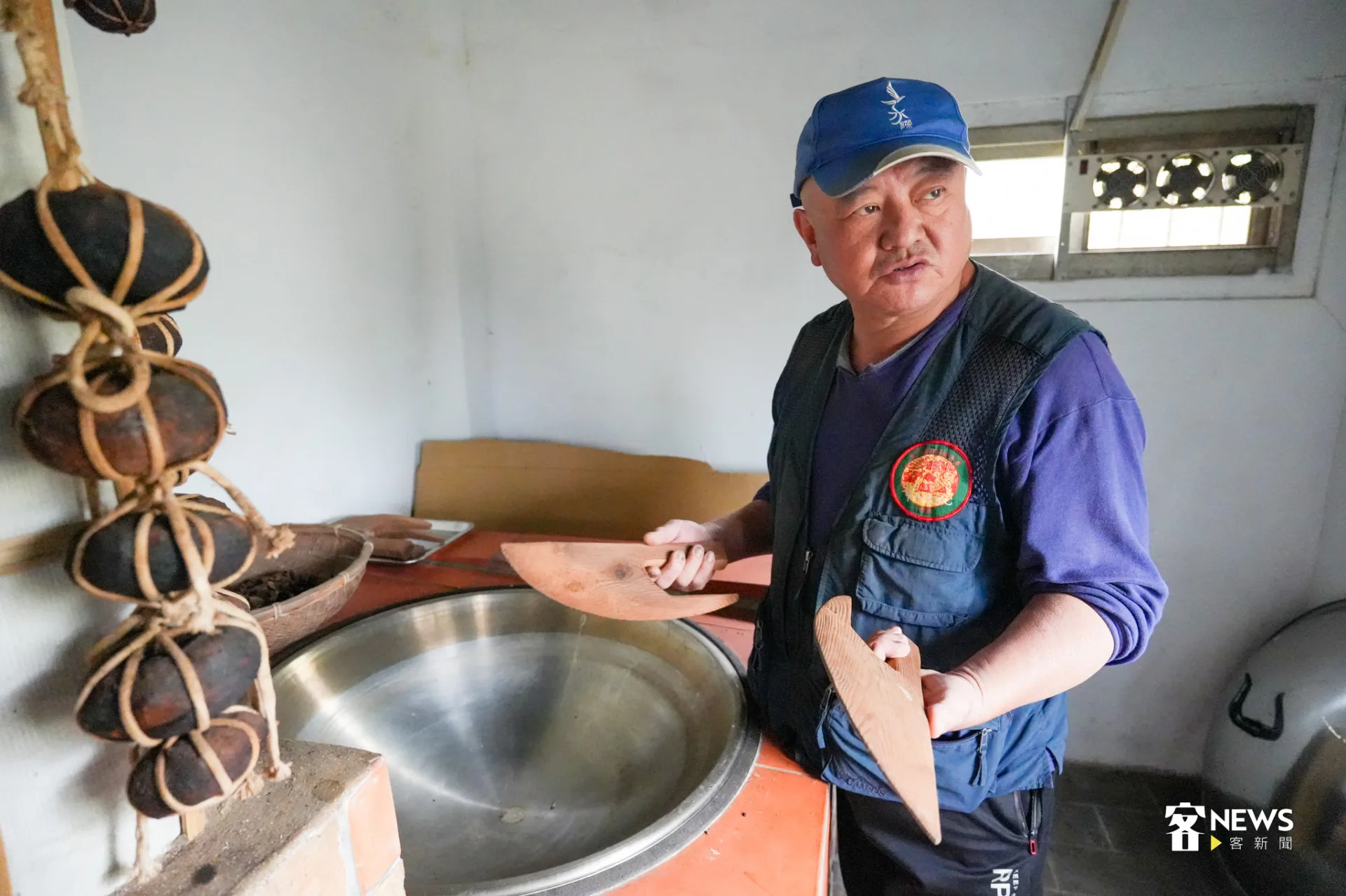 劉還月在傳統爐灶前，講解如何炒茶。蔡依璇攝