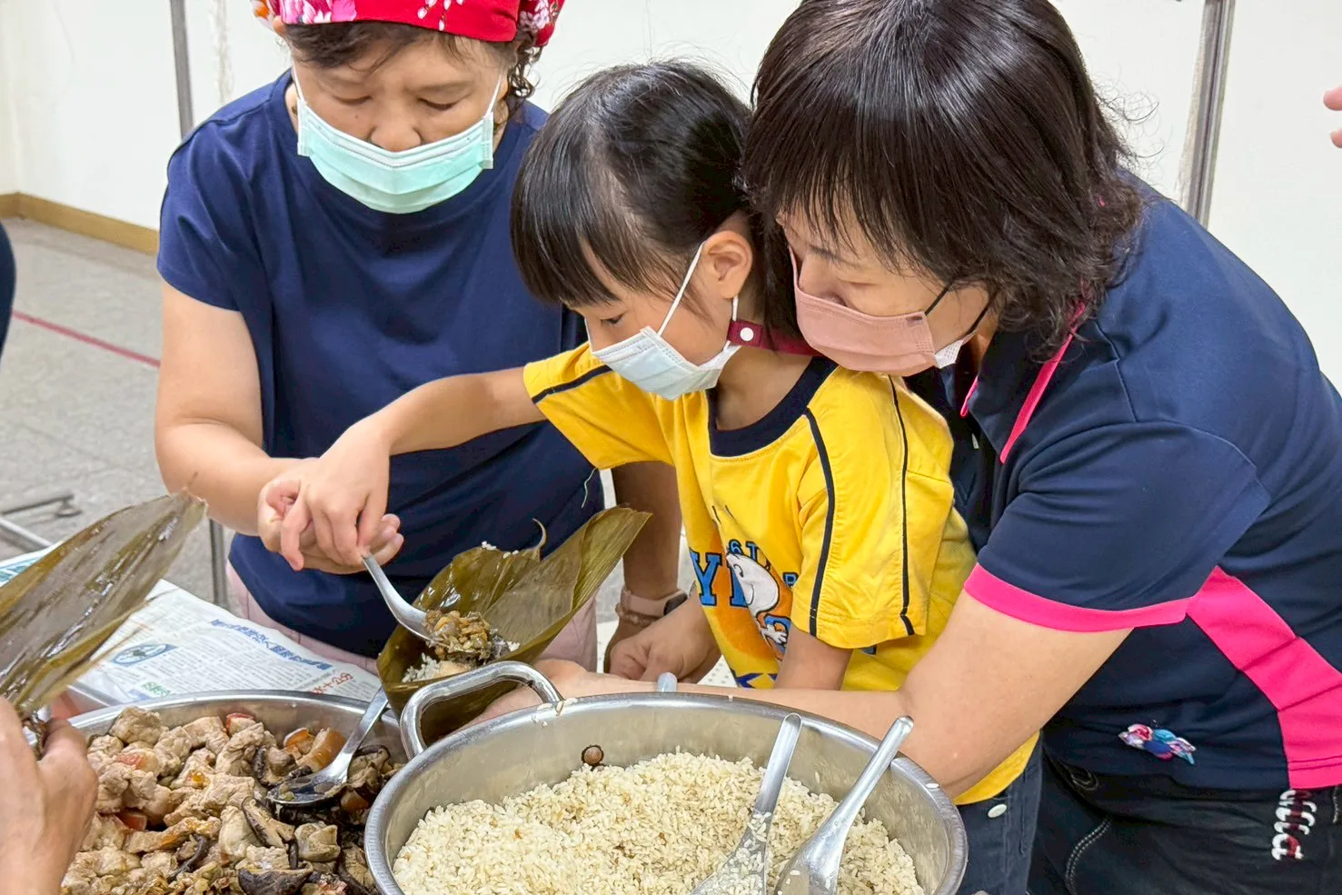 火焰蟲非營利幼兒園今(29)日上午在客家文物館舉辦包粽活動。高雄市客委會提供