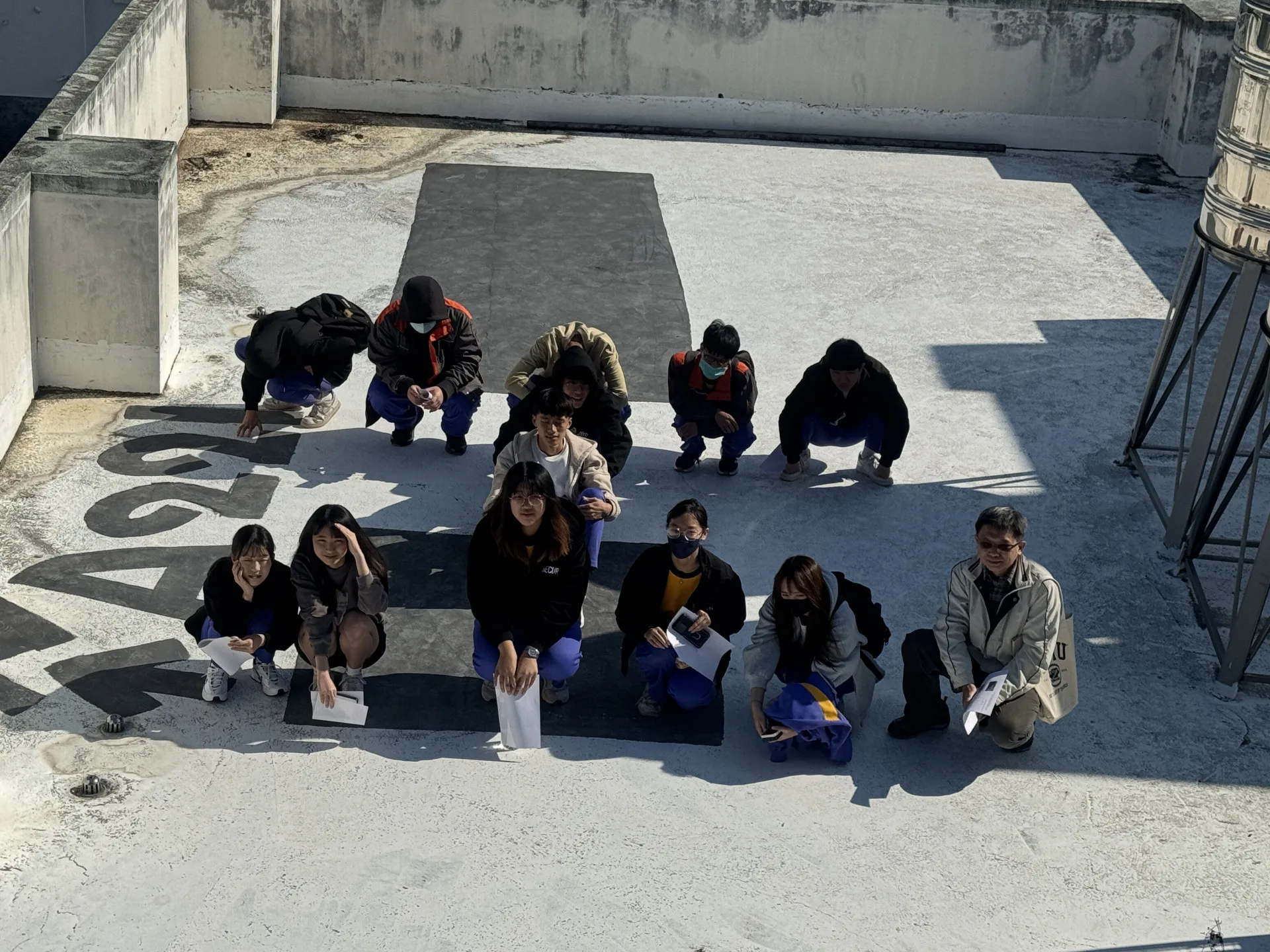 東勢高工建築科學生在東勢地政所頂樓衛星接收站排出「工」字。台中市政府提供