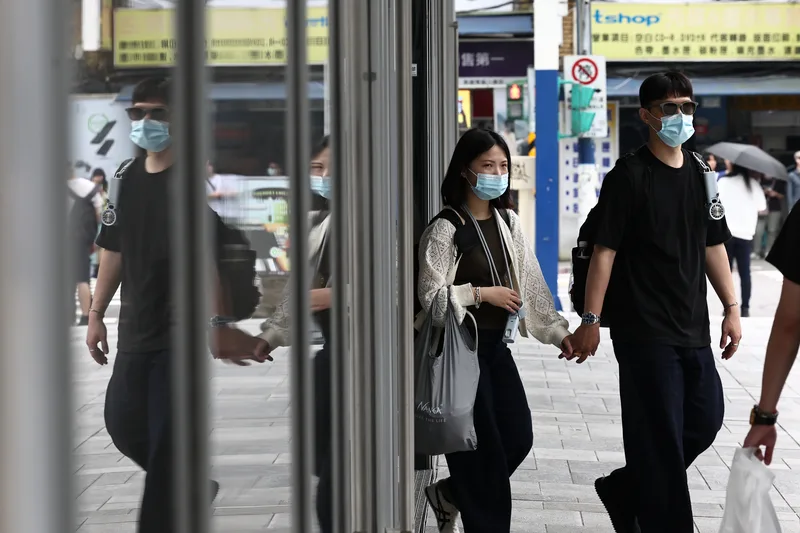 國內COVID-19疫情升溫，疾管署建議民眾可自主戴口罩，做好自我防護。圖為1日台北市中正區街頭民眾戴口罩防疫。中央社