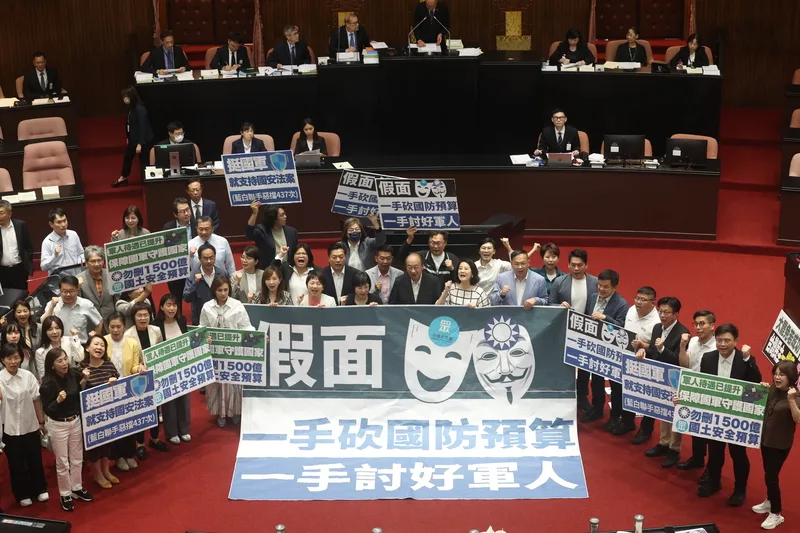 立法院會10日三讀修正《軍人待遇條例》部分條文。圖為民進黨團拿起手舉版。中央社