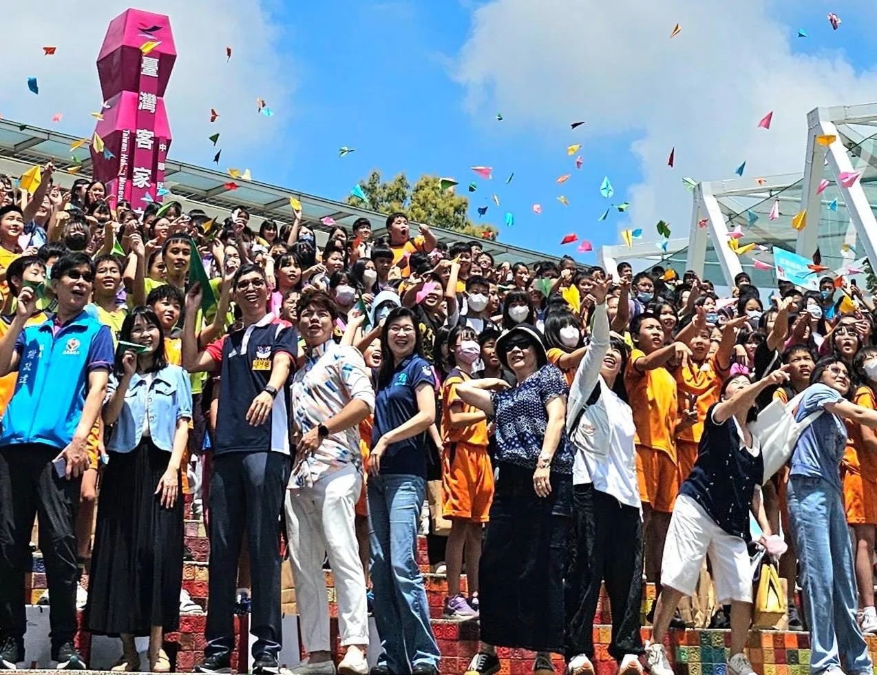 參加客家成年禮畢業生向空中投出象徵夢想起飛的紙飛機。