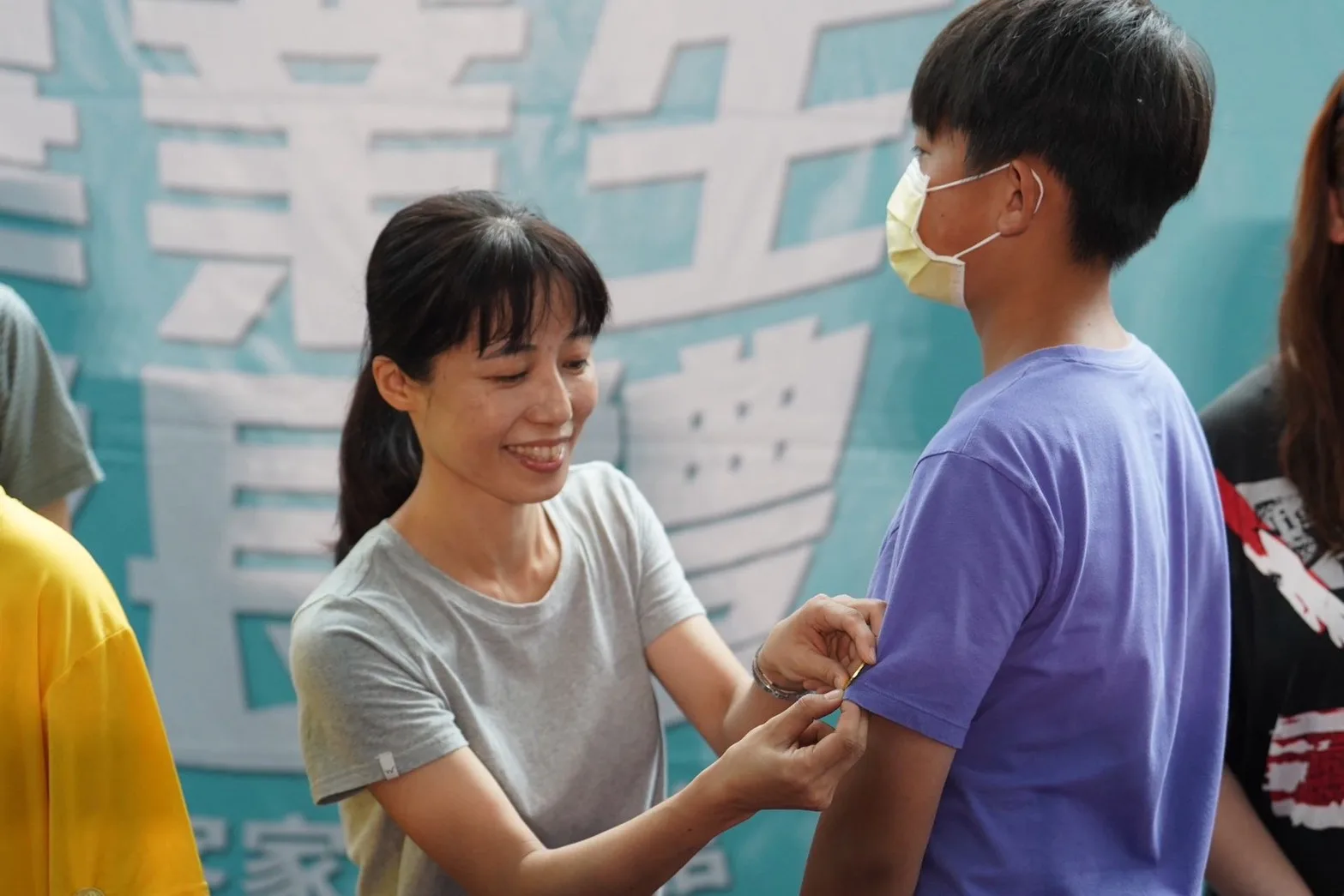 師長替畢業生別上代表客家精神的「硬頸」徽章。