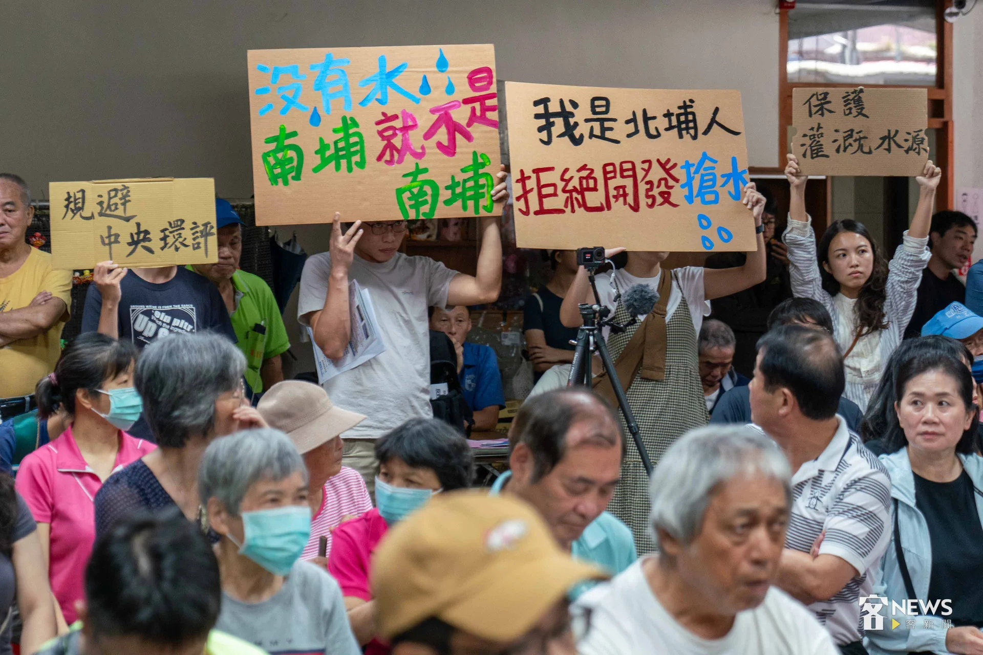 北埔鄉民眾高舉抗議標語,質疑開發案將影響到北埔全鄉民生用水。李台源攝