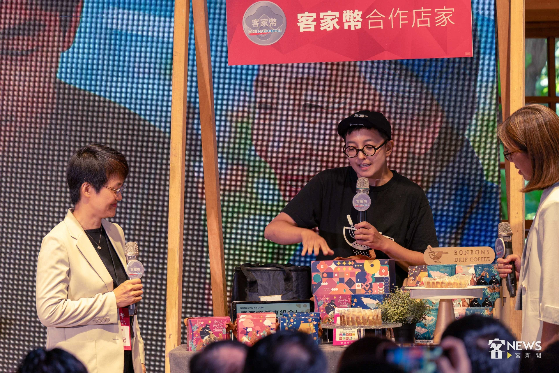古秀妃(左)與示範店家展示客家幣使用流程。李台源攝