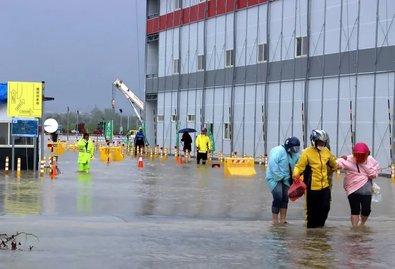 嘉義縣28日清晨起降豪大雨，位於嘉義科學園區興建中的台積電先進封裝廠工地淹水，員工涉水通行。中央社