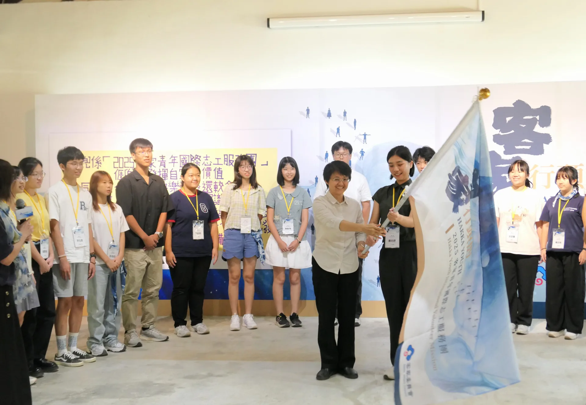 客委會主委古秀妃授旗給2025客家青年國際志工服務團代表蔡明恩。客委會提供