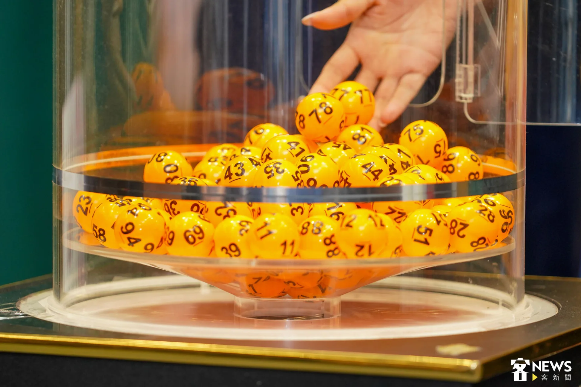 工作人員先將1號到99號彩球放入機器中，抽出的彩球數字，就是中獎的身分證末兩碼。朱愷元攝