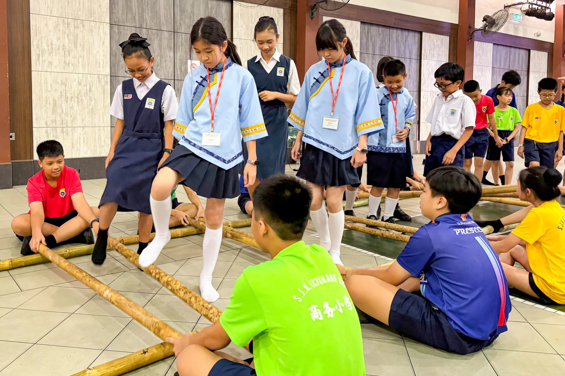 客家合唱團與商務華小學童一起分組文化交流,包括竹竿舞、蠟染、沖格等馬來傳統舞蹈、手藝及遊戲,台馬兩國孩子其樂融融。高雄市客委會提供