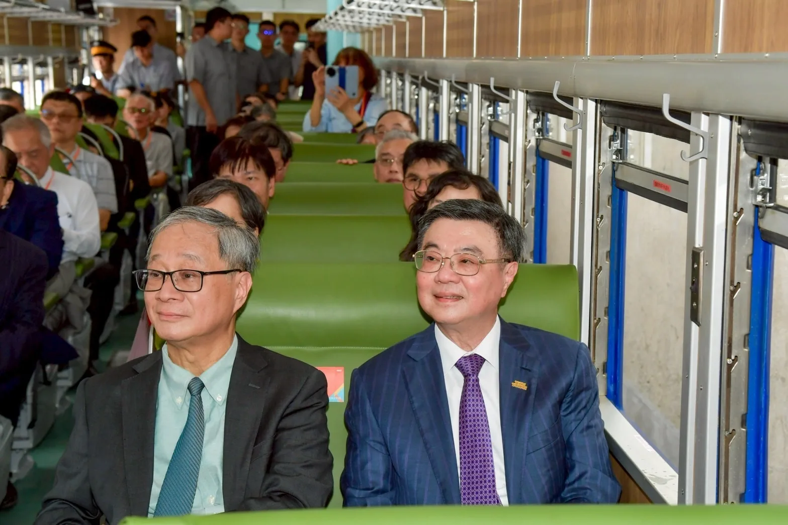 行政院長卓榮泰(右)與文化部長李遠(左)體驗搭乘藍皮客車。行政院提供