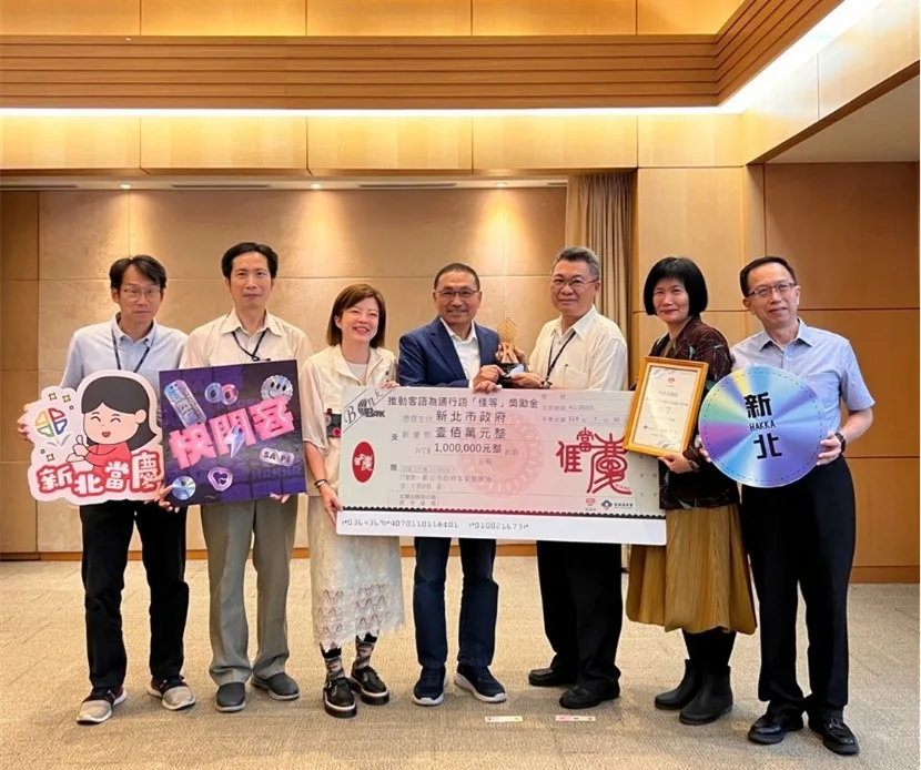 新北5年5度獲獎，持續榮獲客家委員會推動客語為通行語之佳等暨獎勵金100萬元，客家局長劉冠吟（左3）率團隊在市政會議獻獎予侯友宜市長（左4）。新北市客家局提供