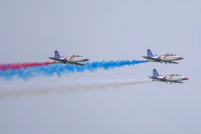 空軍5日在高雄岡山基地舉辦「雷虎小組傳承交接典禮暨勇鷹高教機噴煙性能展示」，圖為AT-3自強高教機以3機編隊飛行並施放3色彩煙。中央社
