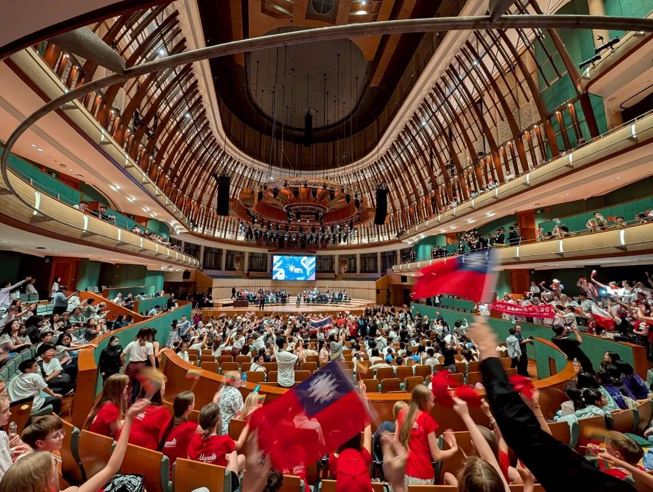 沂風室內合唱團參加新加坡國際合唱節榮獲雙獎殊榮,開心在場內揮舞國旗。