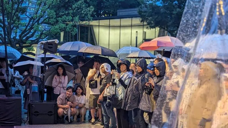 演出期間雖頻遇陣雨，仍吸引日本民眾冒雨追戲。中央社