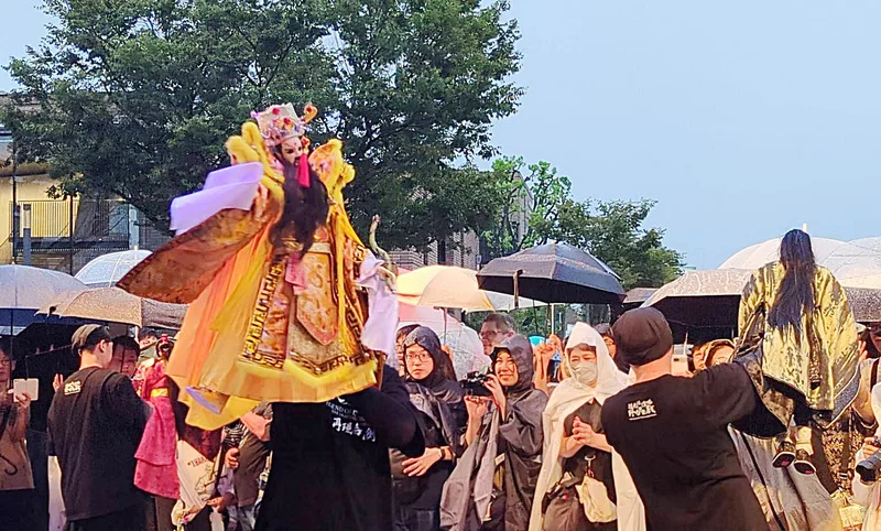 演出團隊特別讓財神爺戲偶走近觀眾互動。中央社