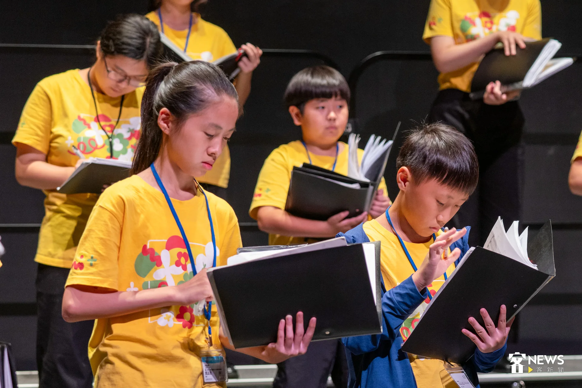 舞台上，神情專注的孩子們，捧著厚厚的樂譜高聲齊唱，不時搭配動作與筆記。洪藝晅攝