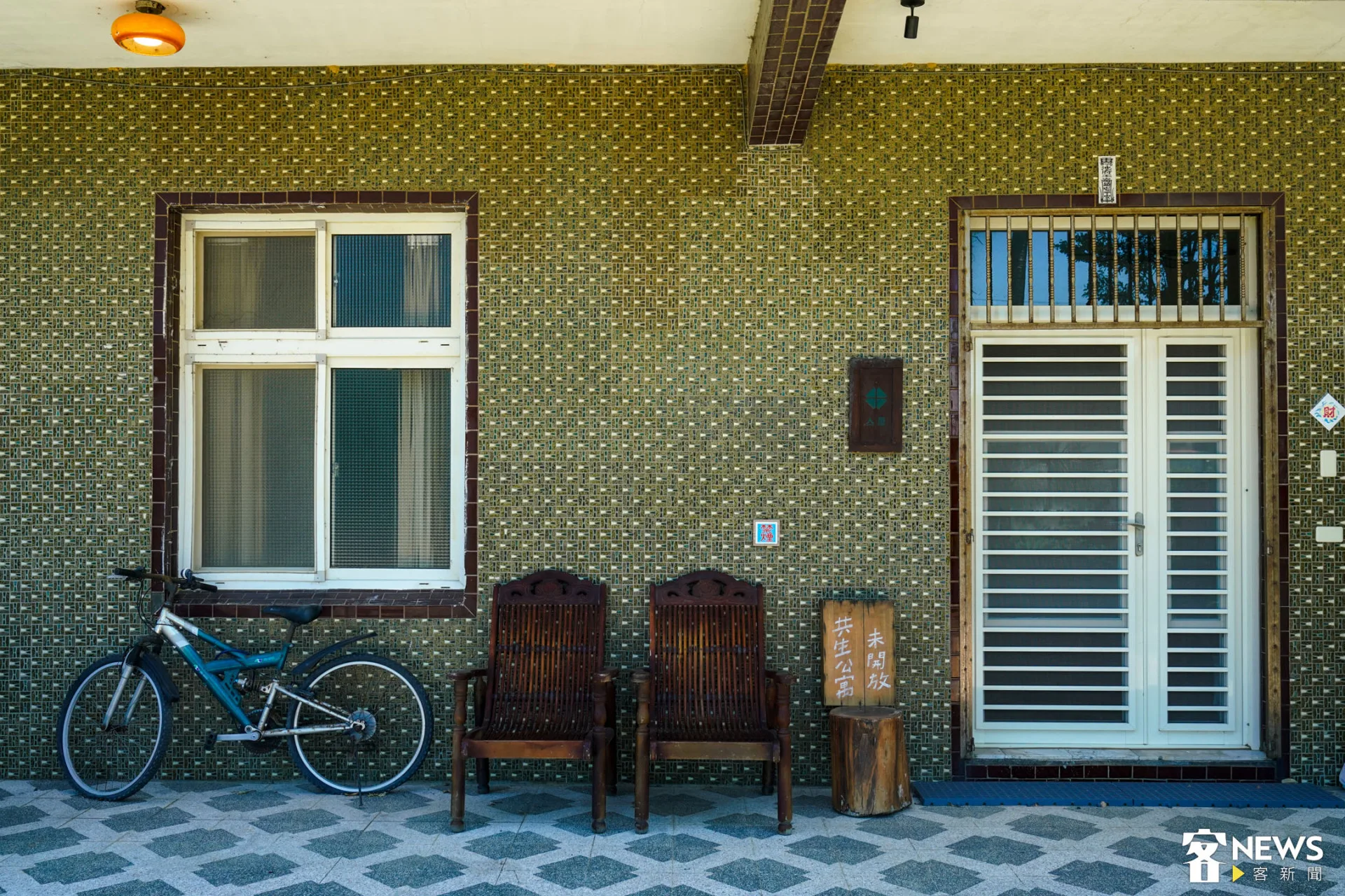共生公寓外觀，磁磚、紗門、木椅皆展現古早氛圍。朱愷元攝