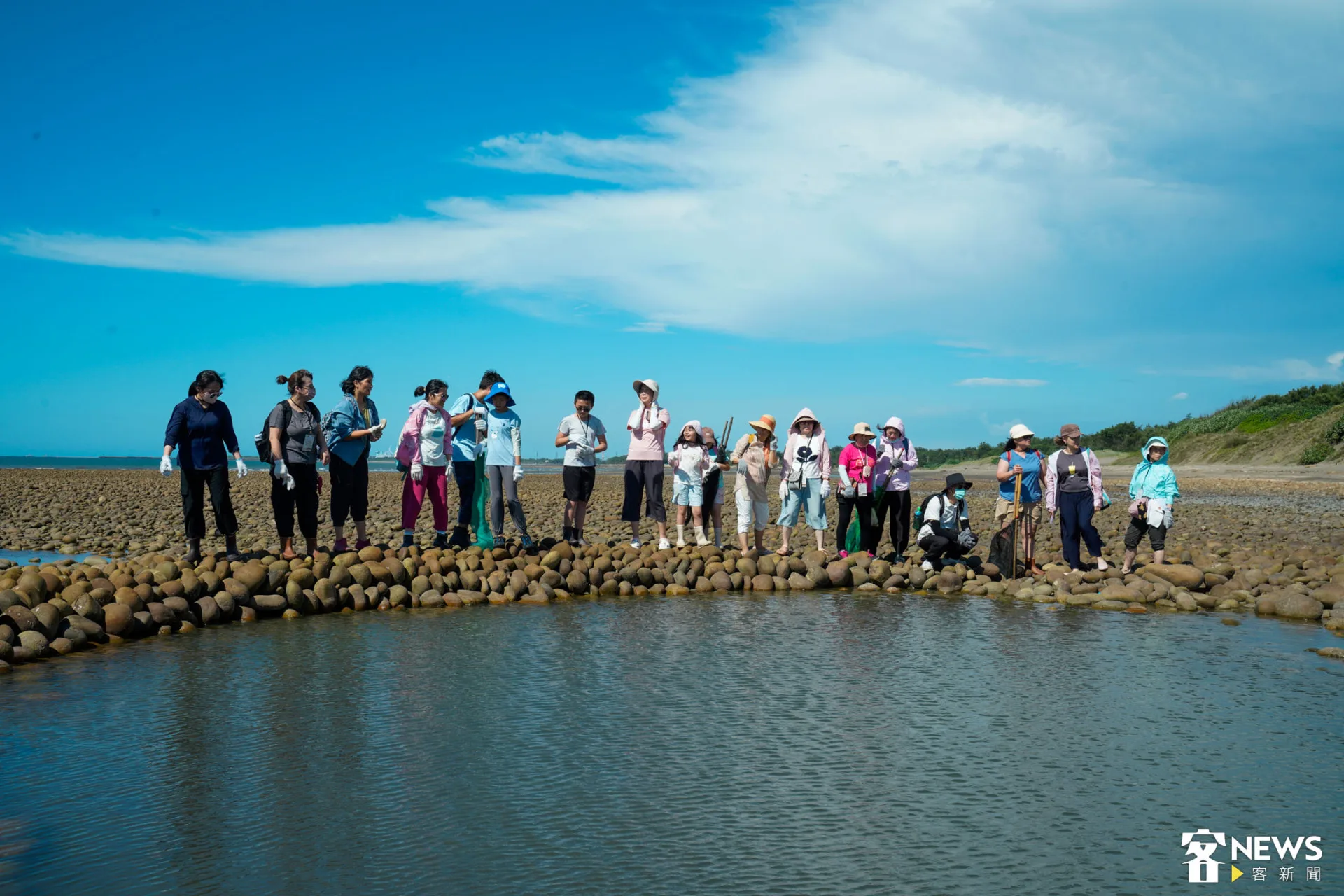 眾人圍在石滬邊。朱愷元攝