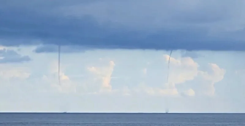 台東蘭嶼海面20日下午出現罕見的雙水龍捲，就像舞動的繩索連接烏雲和水面。台東氣象站21日表示，強烈對流空氣擾動所致。民眾提供