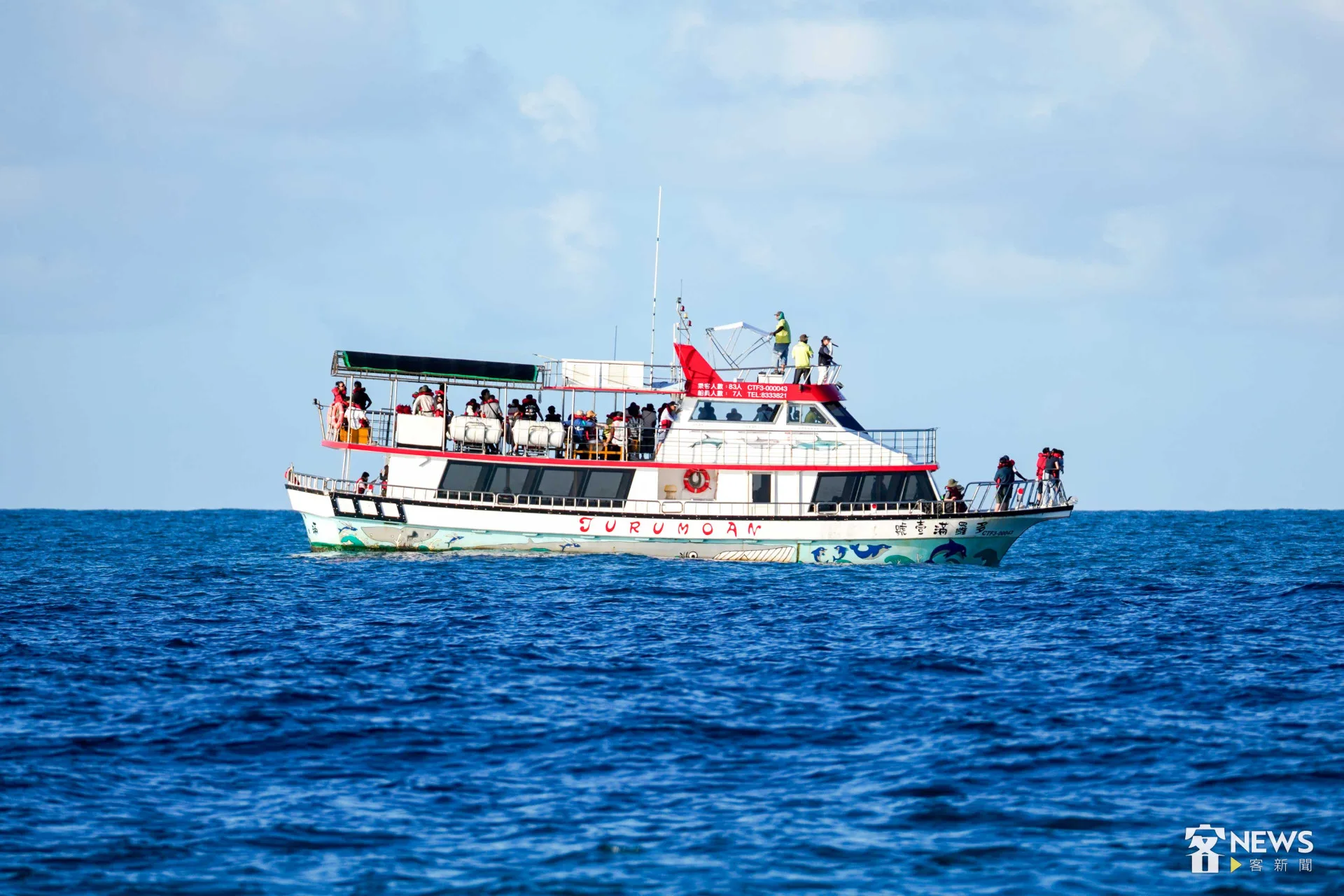 與客語航班同行的賞鯨船，旅客或坐或站，在船舷欣賞飛旋海豚的英姿。李台源攝