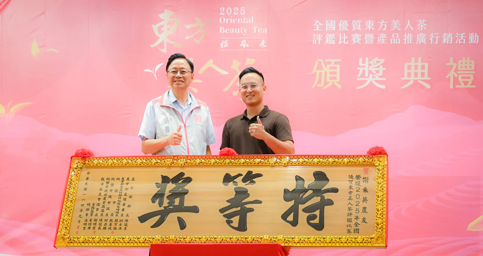 龍潭文新製茶廠奪下東方美人茶評鑑特等獎，張善政（左）頒獎予茶農鍾承泰（右）。