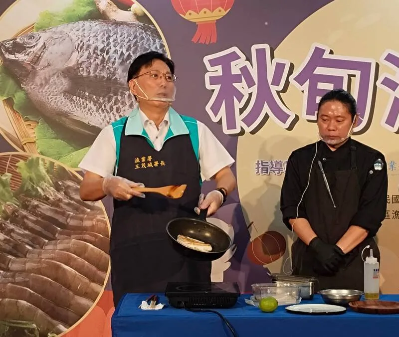 漁業署8日舉辦「秋旬海味祭」記者會，漁業署長王茂城（左）現場示範煎魚，不必放油，將冷凍魚片直接放鍋裡，先煎魚肉再煎魚皮，保證不黏鍋。中央社