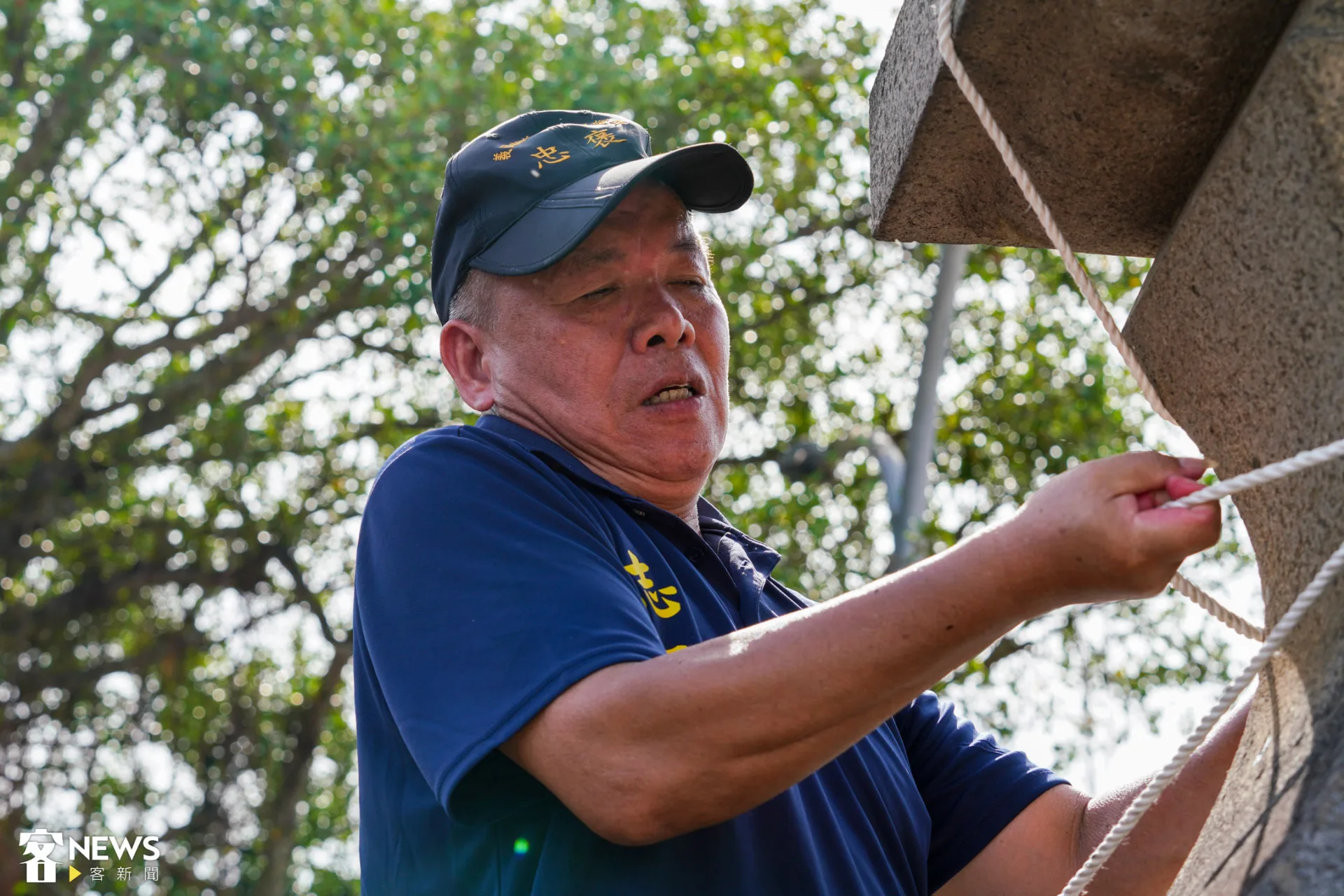志工綁上固定竹身的繩索,拉向廟前左右兩側的石燈。朱愷元攝