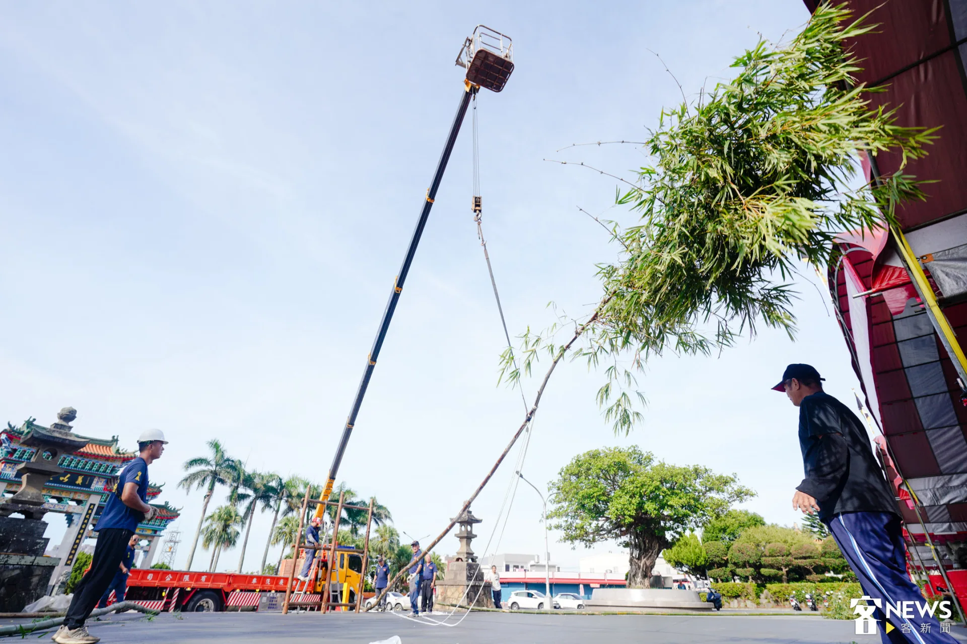 吊車將長達16公尺的燈篙竹緩緩吊起。朱愷元攝
