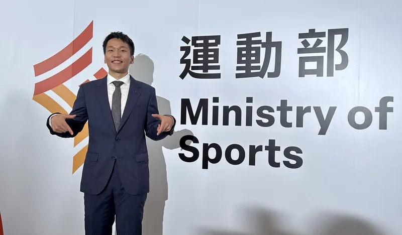 運動部9日在揭牌暨布達典禮，首任部長李洋和運動部看板合影。中央社