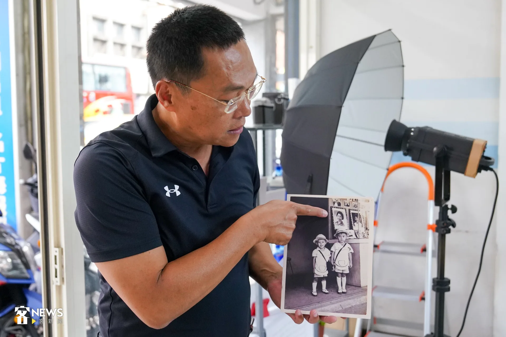 周鴻志展示老照片。洪藝晅攝